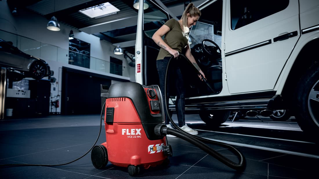 A white vehicle is cleaned with a safety suction nozzle from FLEX.